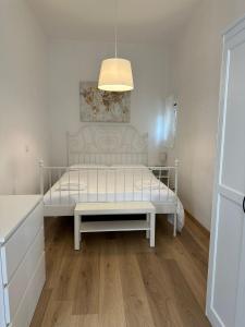 białe łóżko w pokoju z lampką w obiekcie Cami s holidays home w Katanii
