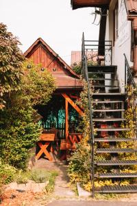 a set of stairs leading to a house with a porch at Poddasze dla Znajomych - apartament z gorącą balią in Kluszkowce