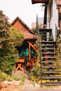 a set of stairs leading to a house with a porch at Poddasze dla Znajomych - apartament z gorącą balią nad Jeziorem Czorsztyńskim - okolica Czorsztyn, Szczawnica, Velo Czorsztyn, Krościenko, Zakopane, Gorce, Pieniny, Tatry in Kluszkowce