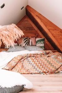 a bed in a room with a wooden ceiling at Poddasze dla Znajomych - apartament z gorącą balią in Kluszkowce