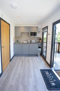 an open kitchen with a wooden floor and a door at Lakeside Lodges in Leicester