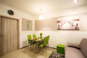 a dining room with a table and green chairs at Sweet apartments with free private parking in Ljubljana