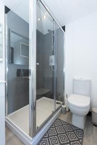 uma casa de banho com um chuveiro e um WC. em Lakeside Lodges em Leicester
