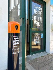 a sign in front of a store with a window at Kyriad Direct Bordeaux Sud Cestas in Cestas