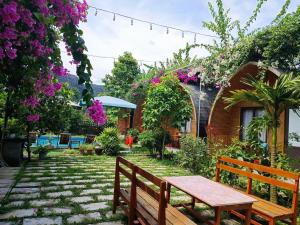 寧平的住宿－Tam Coc Village Bungalow，鲜花房子院子的长凳