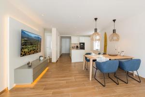 a kitchen and dining room with a dining table and blue chairs at Lichtenberg Lodges in Lichtenberg