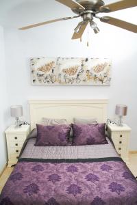 sypialnia z fioletowym łóżkiem i wentylatorem sufitowym w obiekcie 1ra Linea Playa Magic World Luxury Apartament PP3 Pet w mieście Oropesa del Mar