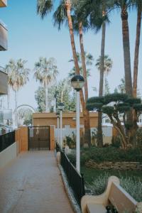 a walkway with palm trees and a fence at 1ra Linea Playa Magic World Luxury Apartament PP3 Pet in Oropesa del Mar