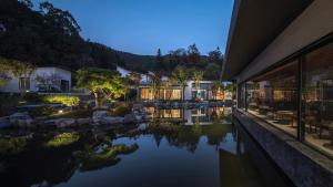 a hotel with a pond in front of a building at Wish Garden Huangshan in Yi