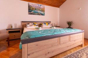 a bedroom with a large bed with a wooden frame at Apartment Aria 150 meters from the beach - by TA Leut agency in Privlaka