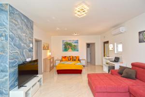 a living room with a red couch and a bed at Apartments Mala Vala 925 - adapted in Fažana