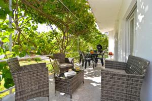a patio with wicker chairs and a table on a porch at Apartments Mala Vala 925 - adapted in Fažana