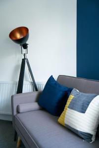 a pillow sitting on a couch next to a lamp at Meadow Apartment in Dumbarton