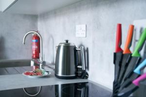 a coffeemaker on a kitchen counter with a plate of food at Meadow Apartment in Dumbarton