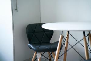 a black chair sitting next to a white table at Meadow Apartment in Dumbarton