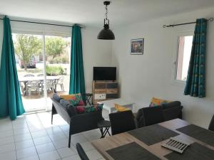 a living room with green curtains and a table and chairs at chez bruno et marie jo in Saint-Saturnin-lès-Avignon