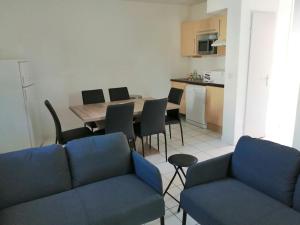 a living room with a blue couch and a table and chairs at chez bruno et marie jo in Saint-Saturnin-lès-Avignon +7 photos