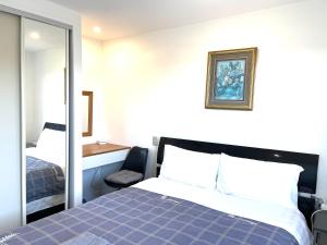 a bedroom with a bed and a mirror at Amber Hill B in Buckland