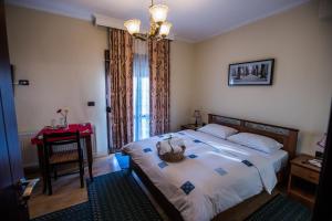 a bedroom with a bed with a table and a window at Vila118 in Voskopojë