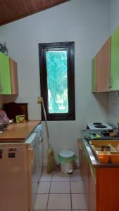 una cocina con escoba y ventana. en Amazonka, en Sombor