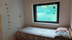 1 dormitorio pequeño con ventana y 1 cama pequeña en Amazonka, en Sombor