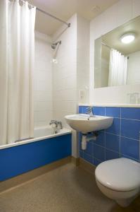 a bathroom with a toilet and a sink and a tub at Travelodge Waterford in Waterford
