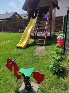 un parque infantil con un tobogán en un patio en AsPa, en Ostrowo