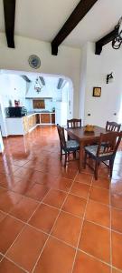 una camera con tavolo e sedie e una cucina di La piccola grande casetta Titina a Ischia