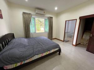 a bedroom with a bed and a large window at Daras house in Ban Klam