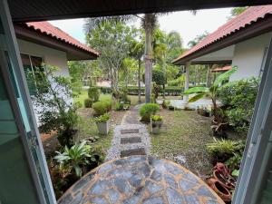 a garden view from a door of a house at Daras house in Ban Klam
