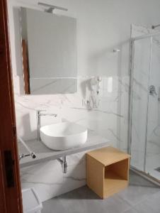 een witte badkamer met een wastafel en een douche bij Villa Silvia b&b in Marina di Camerota