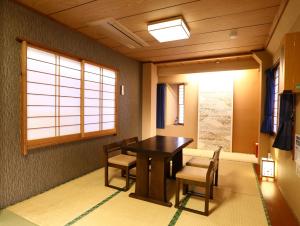 a dining room with a table and chairs and a window at Ryokan Kamogawa Asakusa in Tokyo