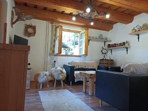 ein Wohnzimmer mit Sofas und einem Tisch mit Tieren darauf in der Unterkunft Chata Smrek a kontaktná MINI ZOO in Jezersko