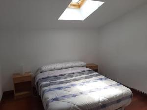 Schlafzimmer mit einem Bett und einem Dachfenster in der Unterkunft Casa rural hermosa en Ispaster con jardin. WIFI in Ispáster