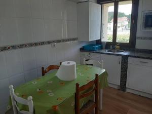 eine Küche mit einem Tisch und einem grünen Tischtuch in der Unterkunft Casa rural hermosa en Ispaster con jardin. WIFI in Ispáster