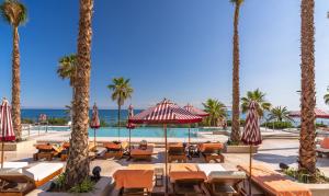 a resort with a pool and chairs and palm trees at El Fuerte Marbella in Marbella