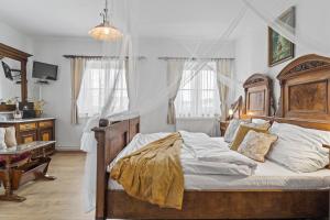 1 dormitorio con 1 cama grande con marco de madera en Pension a restaurace Regina, en Větřní