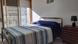 Cette chambre comprend un lit avec une couverture et une fenêtre. dans l'établissement Terra e Mar, à Amorosa