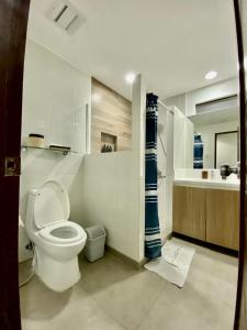 a white bathroom with a toilet and a sink at Paradores de Vigan in Vigan