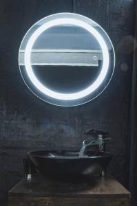 a bathroom with a black sink with a round mirror at Joli appartement rénové dans le centre proche gare in Marseille