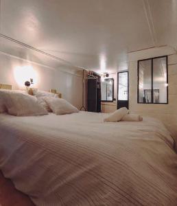 a bedroom with a large white bed with a mirror at Joli appartement rénové dans le centre proche gare in Marseille