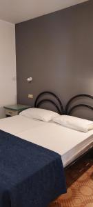 un letto con lenzuola bianche e una coperta blu di Residence Danubio a San Benedetto del Tronto