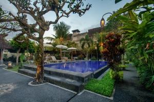 einen Pool in einem Garten mit Bäumen und Pflanzen in der Unterkunft KUDESA Homestay by Pramana Villas in Ubud