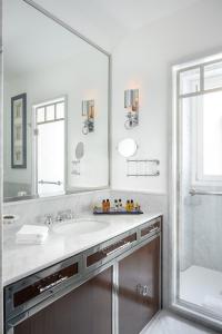 baño con espejo grande y lavabo en Casa Violante Luxury Apartment, en Roma