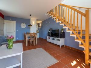 ein Wohnzimmer mit blauen Wänden und einer Treppe in der Unterkunft Feriendorf Rugana - Komfort Appartement mit 2 Schlafzimmern und Terrasse C48 in Dranske + 2 Fotos