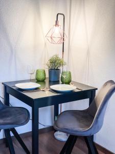 czarny stół z dwoma krzesłami i lampą w obiekcie Apartment für 3 Gäste kostenlose Parkplätze und Lift w Hanowerze