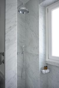 baño con ducha y puerta de cristal en Casa Violante Luxury Apartment, en Roma