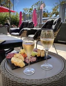 dos vasos de vino sentados en una mesa con comida en La Demeure d'Élodie, en Épernay
