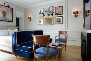 a living room with a bed and two chairs at Casa Violante Luxury Apartment in Rome