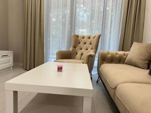 sala de estar con mesa de centro blanca y sofá en DELUXE APARTAMENTS DARIS en Kazanlŭk